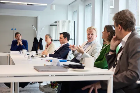 People sit at tables in a conference room talking