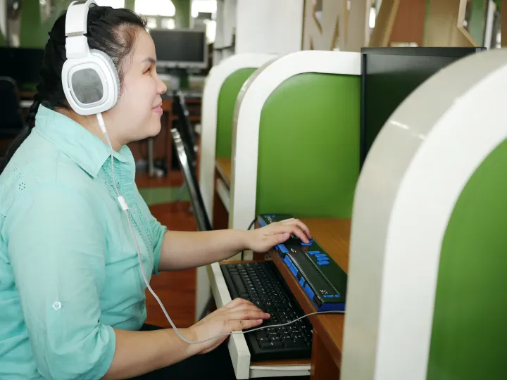 Lady with blindness disability using an assistive technology device. 