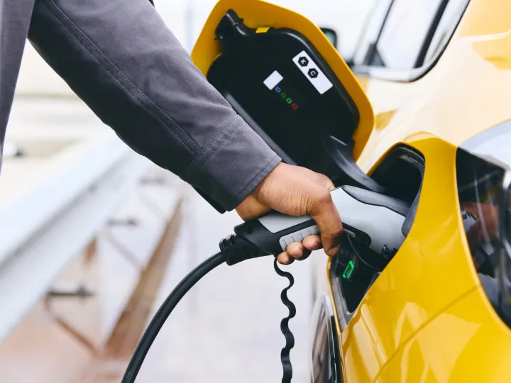 Hand Plugging In Electric Car Outside