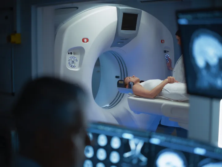 Patient Undergoes MRI Process, in Control Room Doctor Watches Procedure