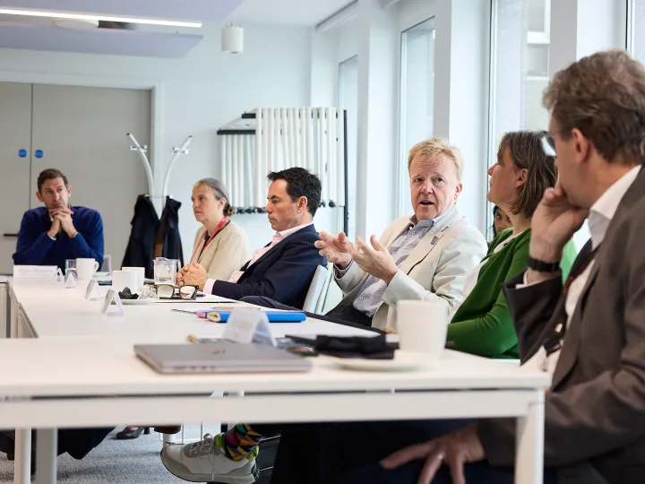 People sit at tables in a conference room talking