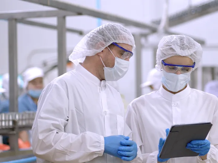 Engineers control quanlity and process of production by application on tablet, discussing project work 