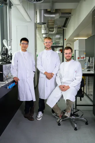 AcouBatt Team in the lab wearing coats and goggles