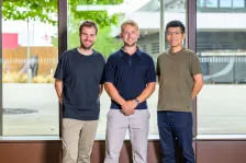 AcouBatt Team photo of three men, two white, one Asian. Smiling at the camera. 