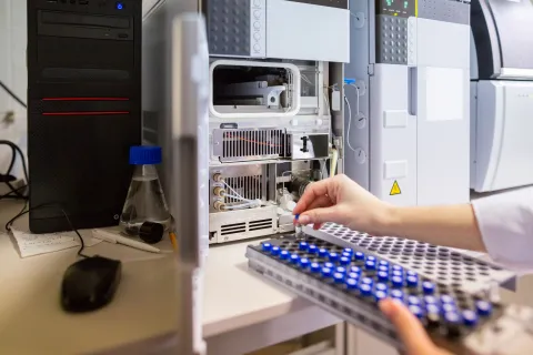 scientists hands placing samples into a machine