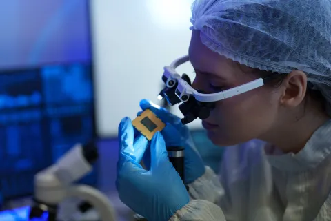 researchers in sterile suits work at a semiconductor manufacturing 