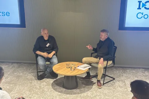 Dr Martin Pule talks to Dr Rick Fagan in front of a crowd at I-O Converse