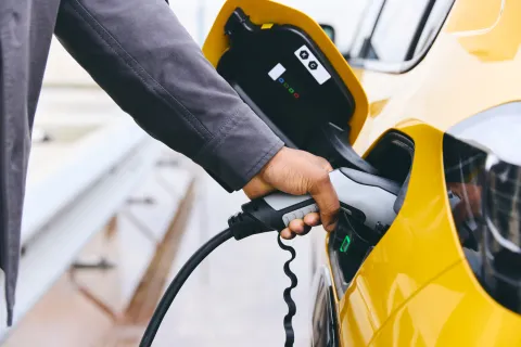 Hand Plugging In Electric Car Outside