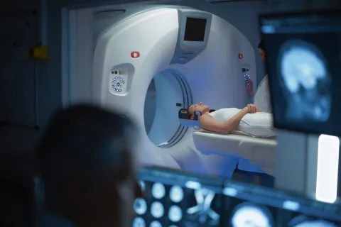 Patient Undergoes MRI Process, in Control Room Doctor Watches Procedure