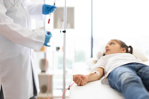 Young girl on a drip with medical professional