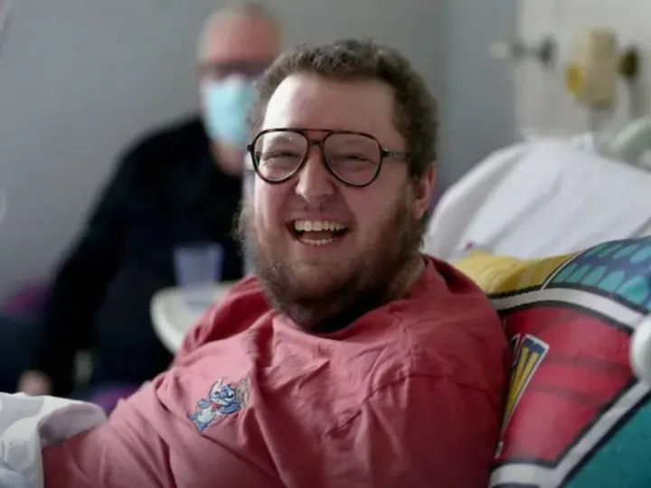 Leukaemia patient Oscar Murphy in a hospital bed, smiling