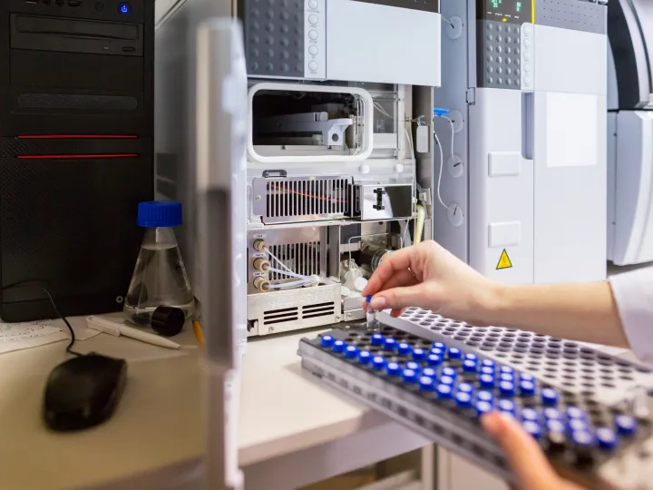 scientists hands placing samples into a machine
