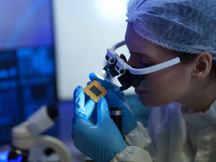 researchers in sterile suits work at a semiconductor manufacturing 