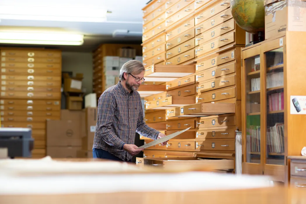 Male researcher looking at maps 