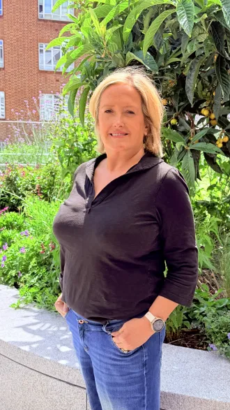 Katie TInkler smiling standing in a garden