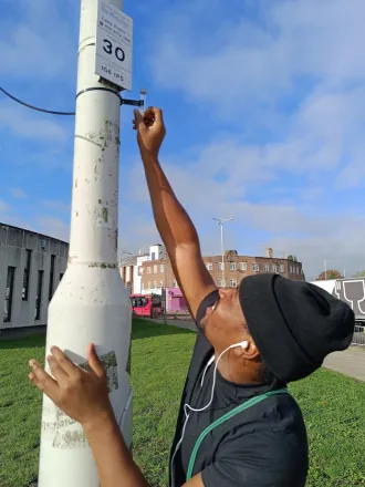 MAPPING FOR CHANGE a volunteer assists Mapping for Change in installing air quality technology 