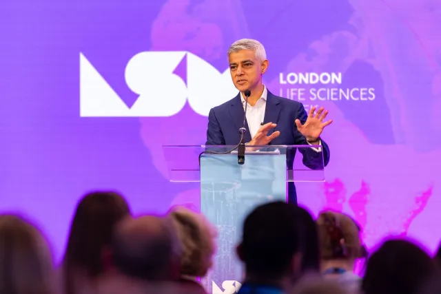 Mayor Sadiq Khan speaking in front of a neon pink/purple background at London Life Sciences Week 2025